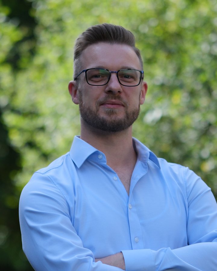 Thomas Czaja im hellblauen Hemd vor grünen Bäumen